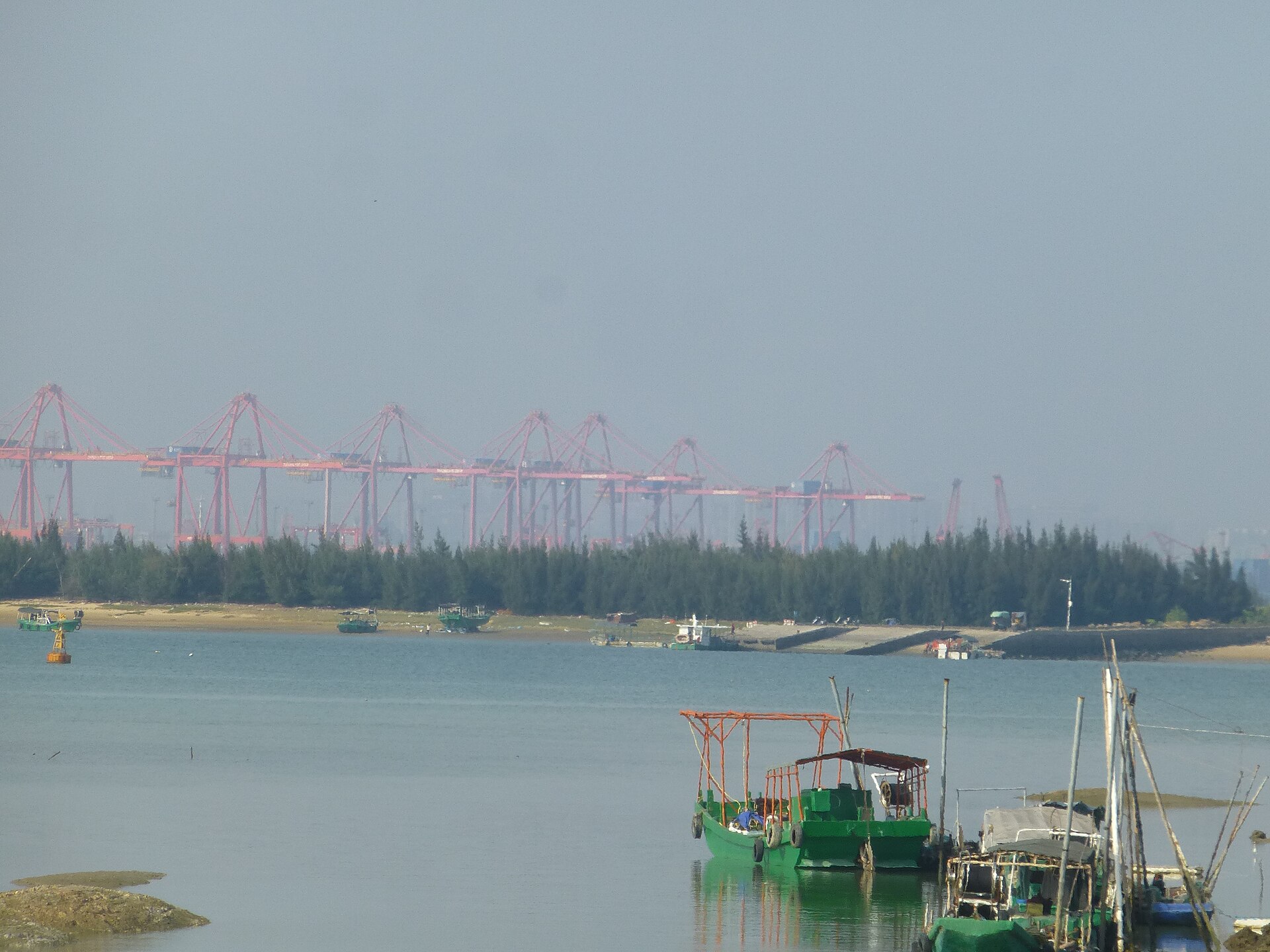 东海岛东岸海堤：长长的石砌堤坝伸向海面，远处是低平的滩涂与天空