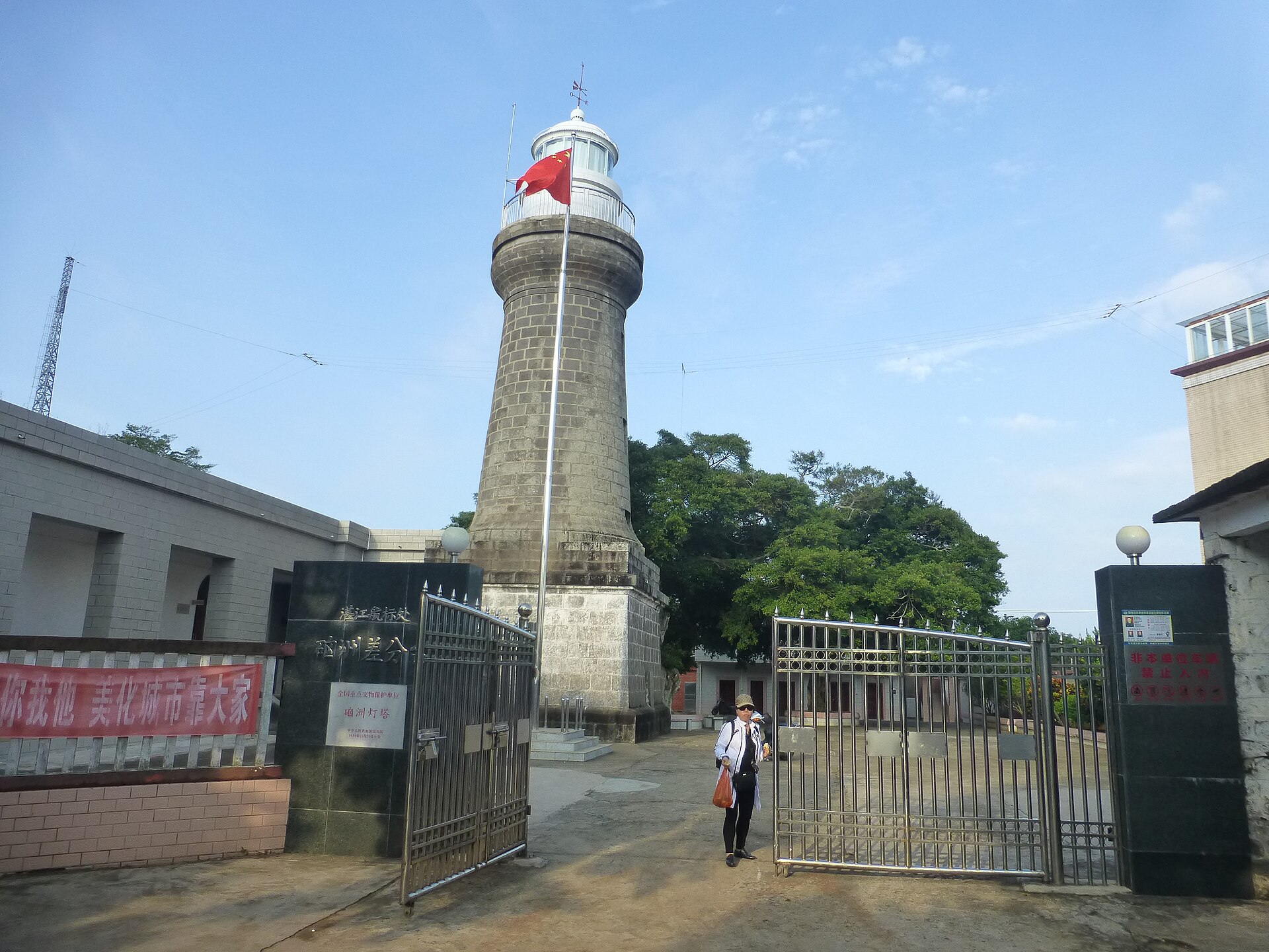 硇洲灯塔：白色塔身的石砌灯塔立在海岛高处，塔顶为深色灯室