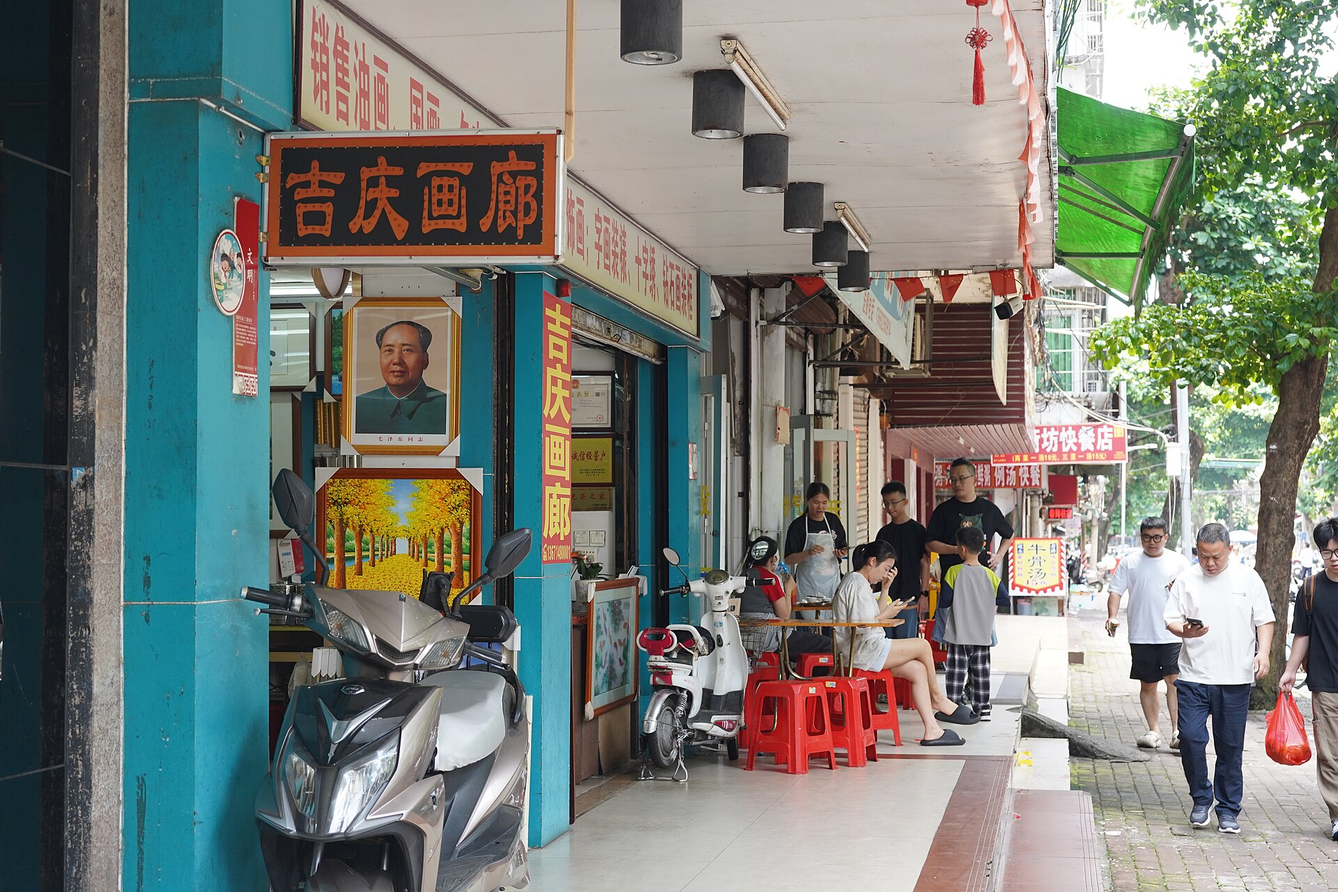 湛江老街街景：沿街店铺与骑楼，行人往来，墙面可见旧式招牌